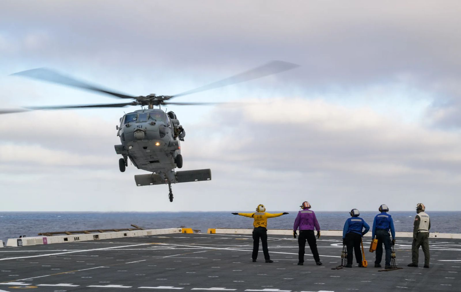 U.S. Navy MH-60 Seahawks from Helicopter Sea Combat Squadron (HSC) 23 are seen arriving on the flight deck of USS John P. Murtha as they prepare to conduct air operations training as NASA, U.S. Navy, and U.S. Air Force teams prepare for the the return of the Artemis II crewmembers to Earth, Monday, April 6, 2026, in the Pacific Ocean off the coast of California. NASA’s Artemis II mission is taking NASA astronauts Reid Wiseman, commander; Victor Glover, pilot; Christina Koch, mission specialist;