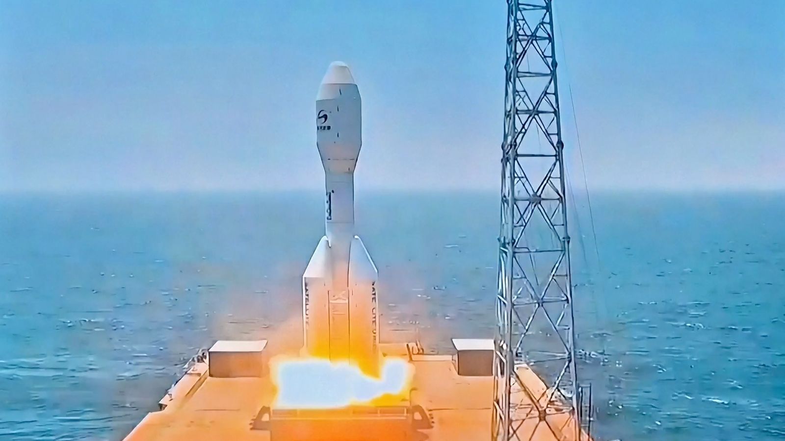 a short white rocket launches from the deck of a ship at sea