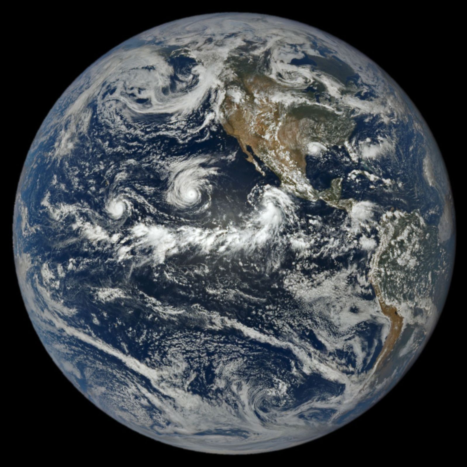 In a full-disk satellite view of Earth, three tropical cyclones—named Lowell, Karina, and Marie—swirl above the blue waters of the Pacific Ocean and to the west of Central America.
