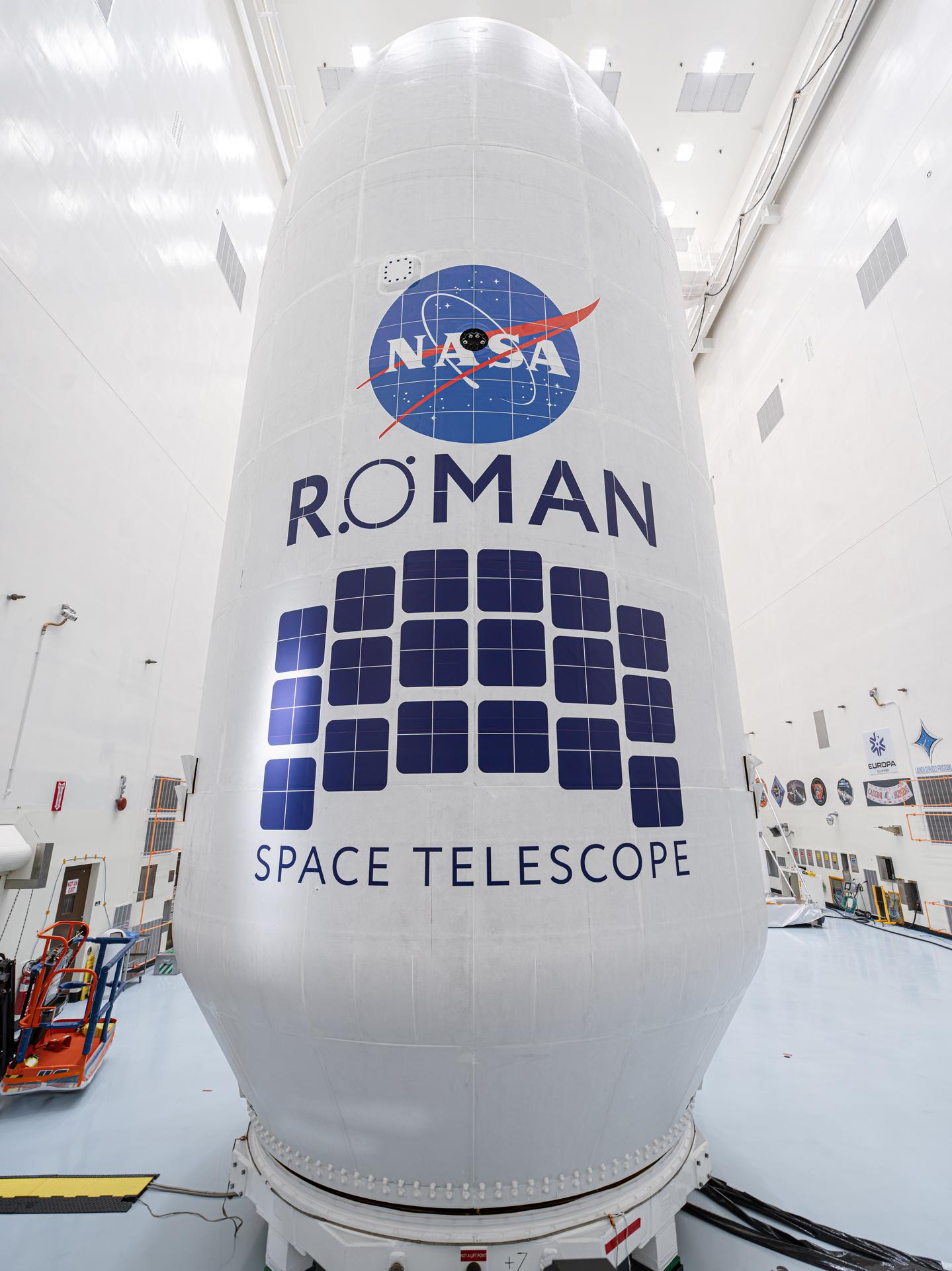 Close-up view of the Roman Space Telescope’s payload, wrapped in white covering with the NASA logo and Roman Space Telescope insignia displayed prominently.