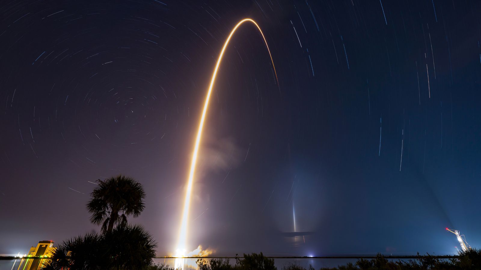 A bright arc streaks through the night sky