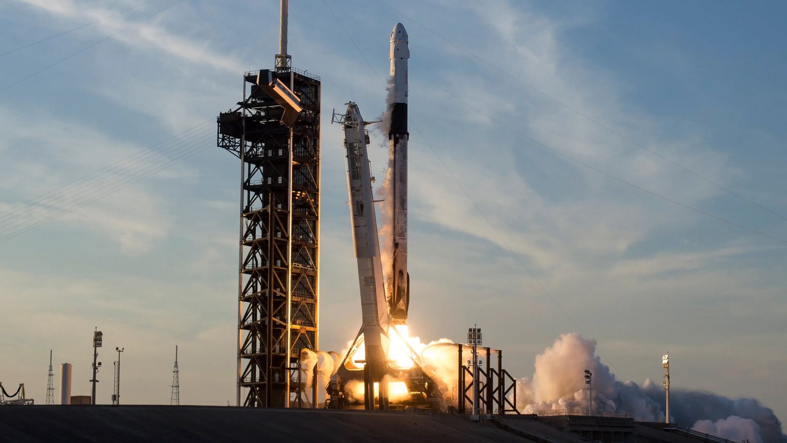 a white rocket launches into a cloudy sky