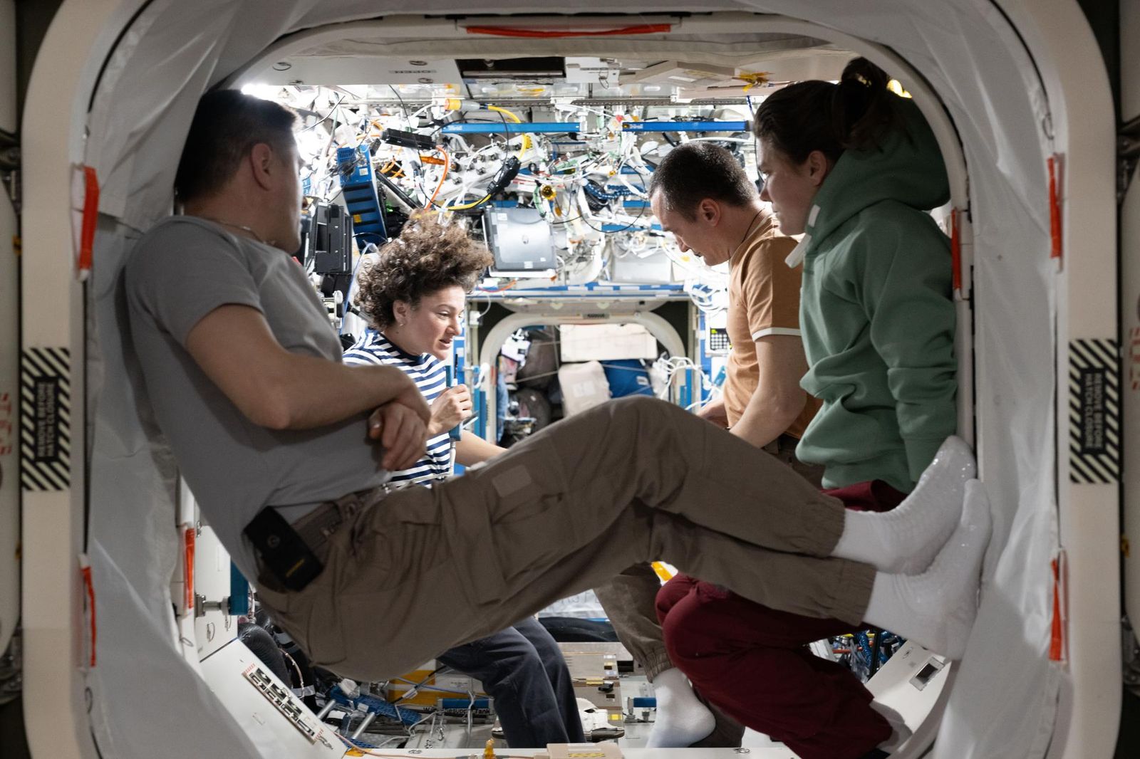 Four Expedition 75 crew members gather together and review procedures for emergency scenarios such as a pressure leak, a chemical leak, or a fire aboard the International Space Station. From left are, flight engineer Andrey Fedyaev of Roscosmos, station commander Jessica Meir of NASA, and Roscosmos flight engineers Pyotr Dubrov and Anna Kikina.