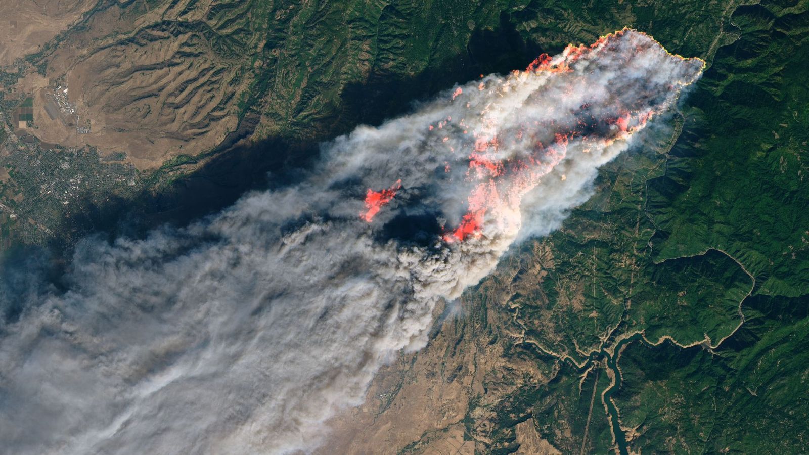 A view of a wildfire with smoke from a satellite's point of view.