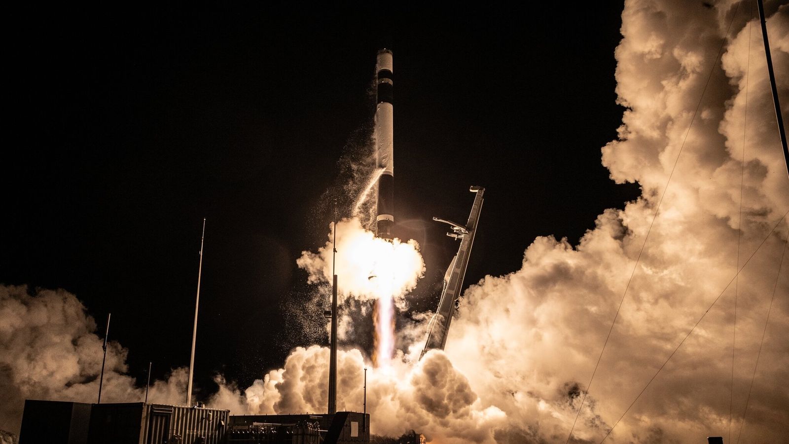 a black and white rocket launches into a dark night sky