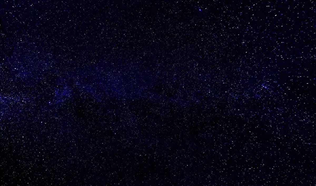 A wide-field view of distant galaxies and star clusters photographed through a telescope, showing the vast cosmic landscape that Roman will survey, with billions of stars and nebulae scattered across the frame.