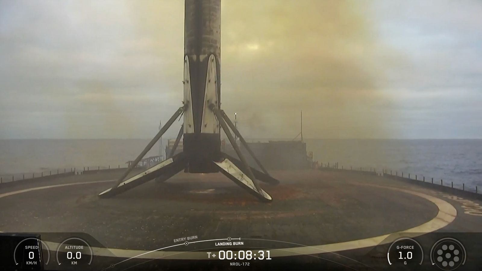 The first stage of a SpaceX Falcon 9 rocket rests on the deck of a ship at sea