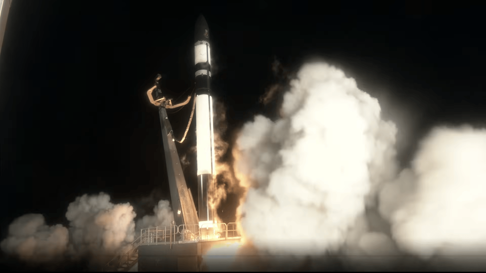 A dark rocket ignites its engines, lifting off a launch pad in a dark night setting.