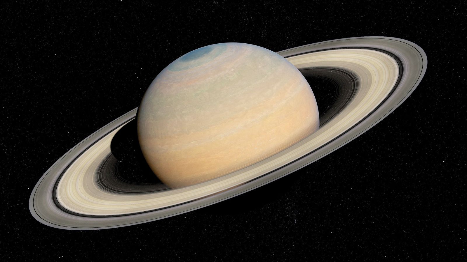 close up view of saturn with sandy colored rings.