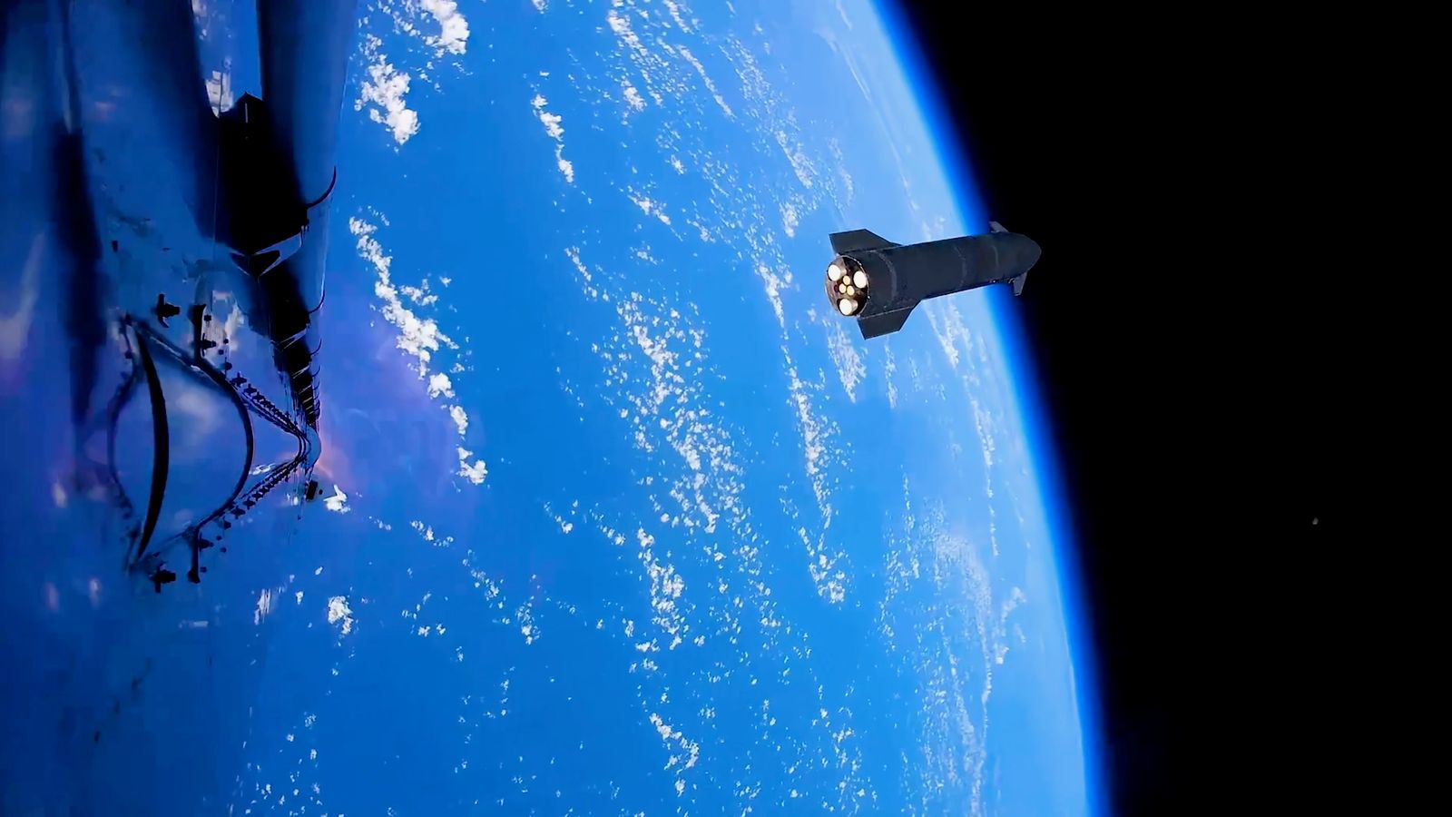 a dark, conical spaceship is seen high above Earth from another spacecraft in space