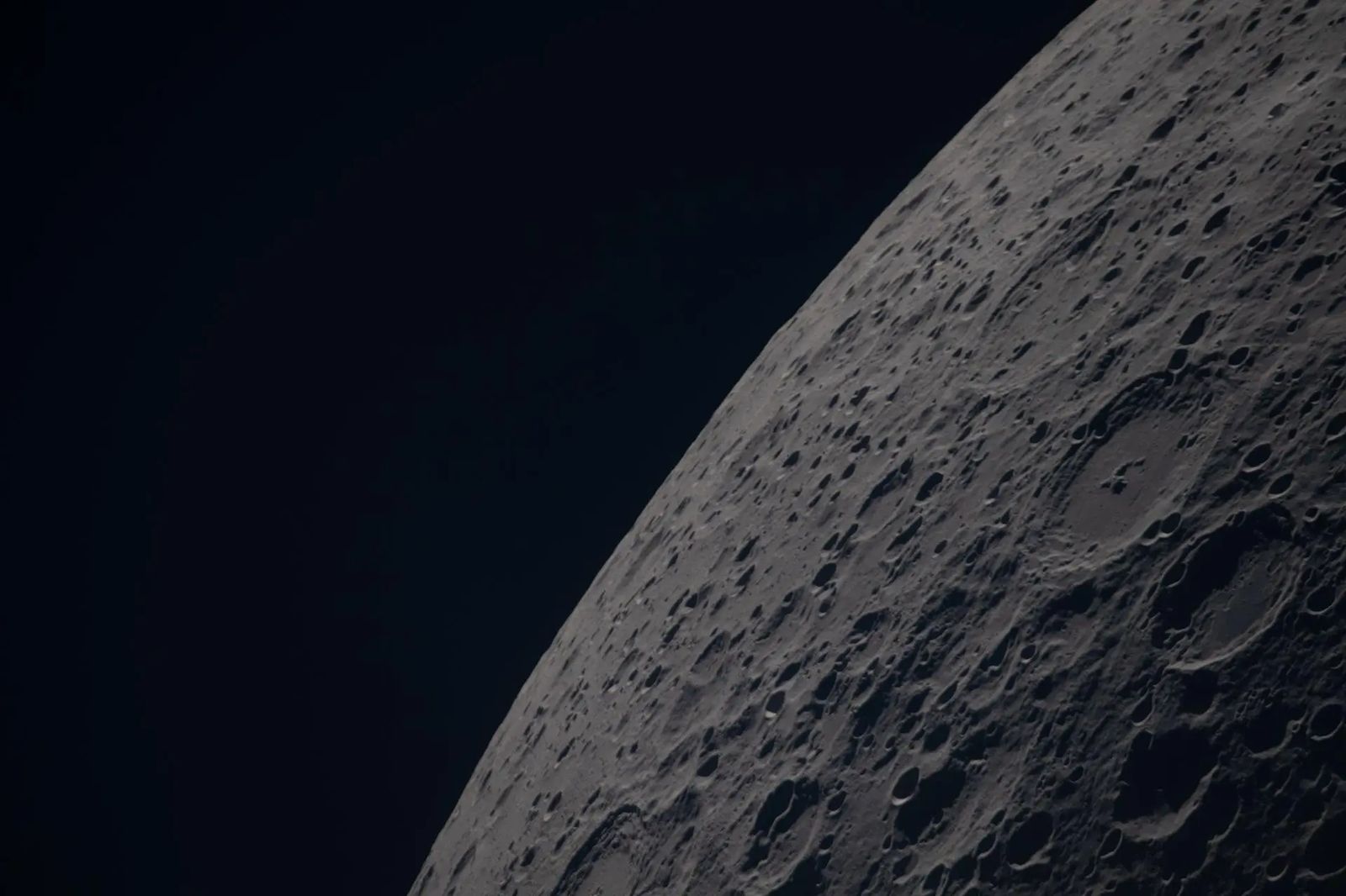(April 6, 2026) – Poynting crater and Keeler crater are visible side by side in the lower right portion of this image of the Moon’s far side highlands. Poynting, positioned above, is a large impact crater with a well-defined rim and relatively smooth interior, indicative of material that has settled following the initial impact. Just below it, Keeler crater appears slightly smaller, with a sharply outlined rim and a more textured interior shaped by subsequent impacts and ejecta. Both features li
