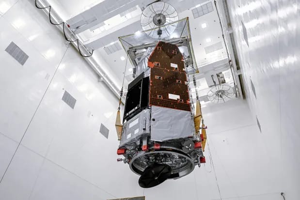 Technicians and engineers inside the Payload Hazardous Servicing Facility at NASA's Kennedy Space Center in Florida use a crane to lift the agency's Nancy Grace Roman Space Telescope to a vertical position on Thursday, June 25, 2026, as processing continues ahead of a launch on a SpaceX Falcon Heavy as early as August 30. (Sydney Rohde (Rocz)/NASA)