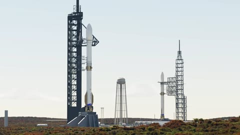 Two rockets stand at neighboring launch towers.