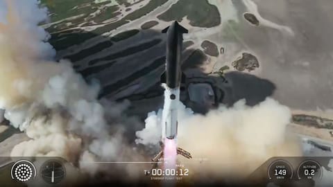 A towering SpaceX Starship Flight 13 rocket lifts off into a blue sky.