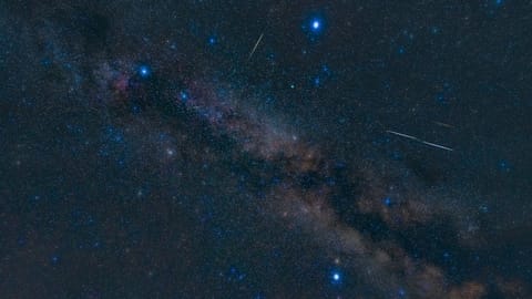 night sky image showing three bright stars forming a triangle, with the milky way glowing between.