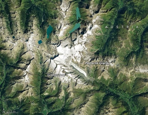Ice in a broad Alpine basin feeds debris-covered glacial ice several kilometers long in the valley below.