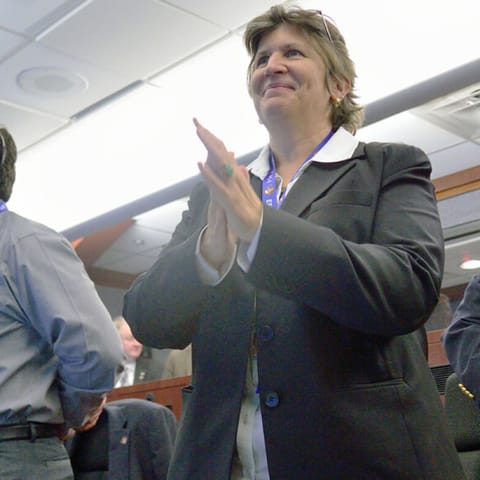 Julie Kramer White applauds alongside NASA coworkers