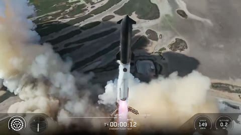 A towering SpaceX Starship Flight 13 rocket lifts off into a blue sky.