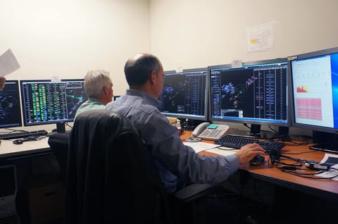 Air Traffic Controllers taking part in an Integrated Demand Management (IDM) research simulation in the Airspace Operations Laboratory (AOL) at NASA Ames Research Center.