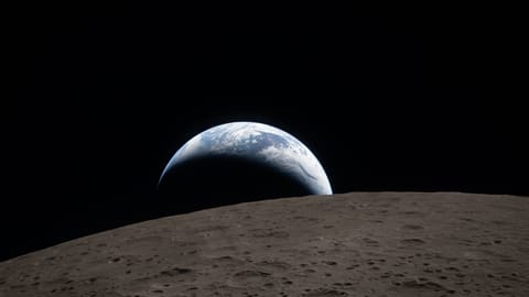 spacecraft photo showing a crescent earth setting above the curved, gray, crater-pocked surface of the moon