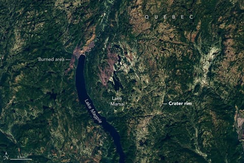 Though subtle, a circular indentation with Lake Marsal near the center is visible in the middle of a mostly green landscape with textured terrain and many lakes.