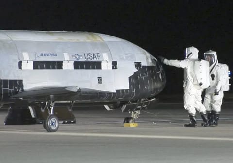 Technicians in self-contained atmospheric protective ensemble suits conduct initial checks on the X-37B Orbital Test Vehicle 1 after its landing Dec. 3, 2010, at Vandenberg Air Force Base, Calif. The X-37B conducted on-orbit experiments for more than 220 days during its maiden voyage. (U.S. Air Force photo/Michael Stonecypher) (Photo by DoD/Corbis via Getty Images)