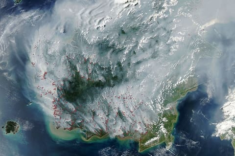 The locations of MODIS fire detections are depicted with small red circles. Most are visible on the southern side of the island.