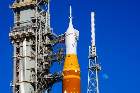 The Moon is seen behind the SLS (Space Launch System) and Orion spacecraft, atop the mobile launcher on January 28, 2026. The rocket is currently at Launch Pad 39B at NASA’s Kennedy Space Center in Florida, as teams are preparing for a wet dress rehearsal to practice timelines and procedures for the launch of Artemis II. 508 Description:The Moon is seen shining over the SLS (Space Launch System) and Orion spacecraft, atop the mobile launcher on January 29, 2026. The rocket is currently at Launch