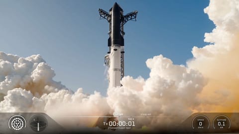 A towering SpaceX Starship Flight 13 rocket lifts off into a blue sky belching twin plumes of smoke.
