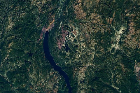 Though subtle, a circular indentation with Lake Marsal near the center is visible in the middle of a mostly green landscape with textured terrain and many lakes.