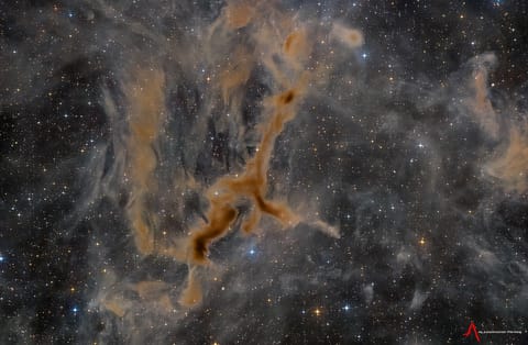 A light brown dust plume, dense at its center and more diffuse toward its edges, extends horizontally across an orange-brown and green landscape. Scattered white clouds cover some of the scene.