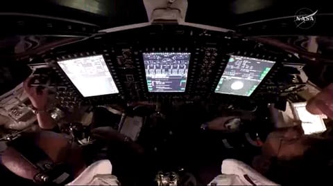 A view over the shoulders of NASA astronauts Victor Glover (left) and Reid Wiseman (right), pilot and commander, respectively, inside the Orion spacecraft as they participate in a proximity operations demonstration. This demonstration tests the spacecraft’s ability to manually maneuver relative to another spacecraft, the interim cryogenic propulsion stage, after separation, using its onboard navigation sensors and reaction control thrusters.