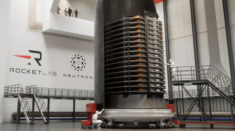 A stack of thin satellites sits in half a rocket fairing in a clean room.