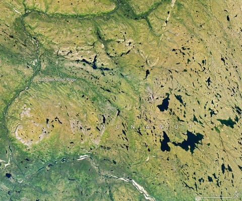 A river winds through a mostly green tundra landscape in summer, dotted with numerous lakes.