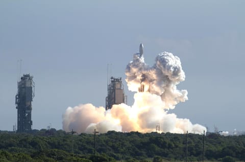 A rocket launches and is engulfed in exhaust