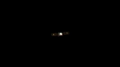 photo of a cube-shaped satellite in deep space, taken from a distance by another satellite
