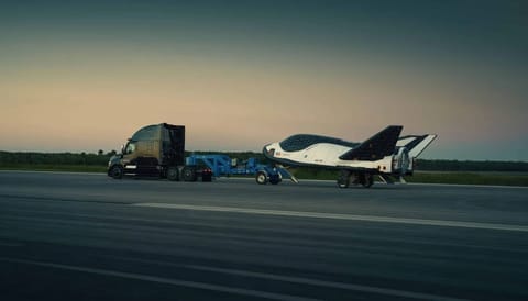 TOS-L-Dream-Chaser-Tow-01 A tow truck hauls Sierra Space's Dream Chaser on the runway to test out its landing capability at the former space shuttle landing facility at Kennedy Space Center. (Courtesy/Sierra Space)