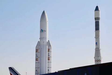 A massive booster standing vertical on a launch pad, all 33 engines glowing white-hot at the base, exhaust plumes billowing outward, the test structure surrounding the rocket backlit by the engine fire, capturing the moment of full-power ignition