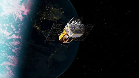 illustration of a golden and gray spacecraft orbiting earth at night