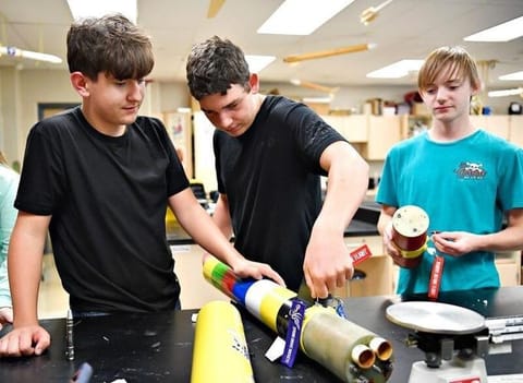 Rocket team members Greyson Straub-Levis, 15; Micah Henning, 16; and Logan Shearer, 15; from left, examine the segments of a rocket during a club meeting at Spring Grove Area High School in Jackson Township on Thursday, Aug. 27, 2026. The students will ...