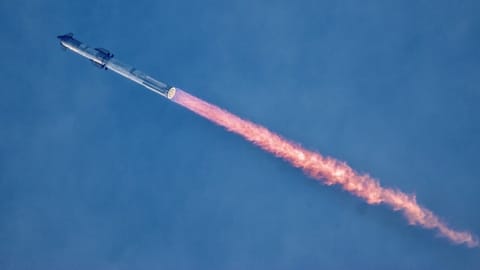 a giant rocket launches against a colorful sky