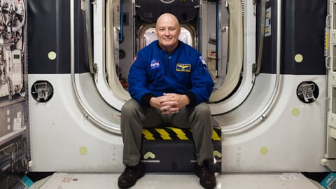 Scott Tingle poses for a photo inside a module of the International Space Station