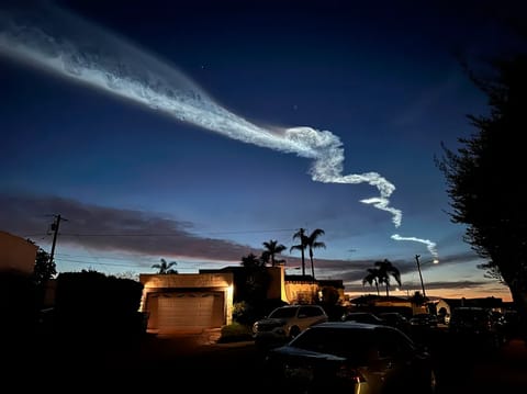 FILE - A contrail from a SpaceX Falcon 9 rocket, which launched from Vandenberg Space Force Base, is seen over homes March 18, 2024, in San Diego. (AP Photo/Gregory Bull, File)